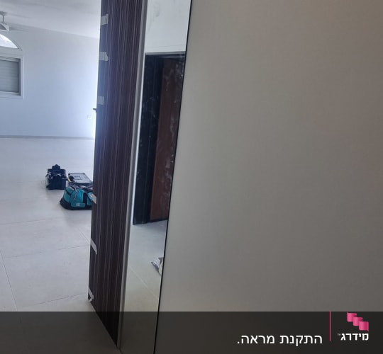 התקנת מראה גבוהה לצד חיפוי קיר דקורטיבי בבית